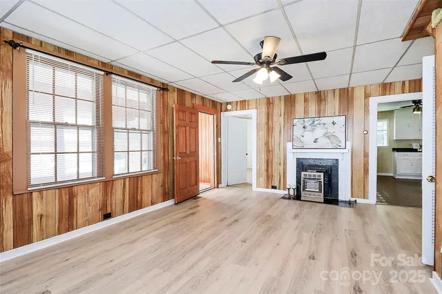 wooden floor fireplace and windows in an empty room
