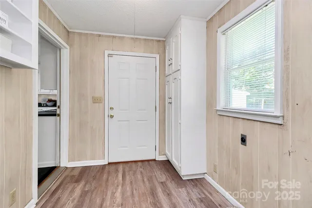 a view of a hallway with wooden floor and closet