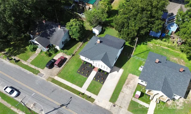 an aerial view of a house with a garden and trees