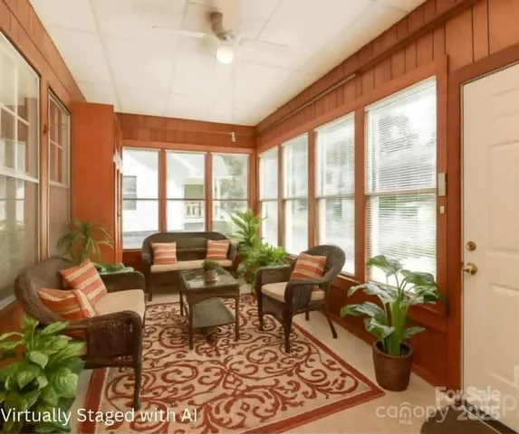 a living room with furniture and floor to ceiling windows