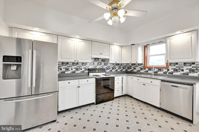 a kitchen with granite countertop white cabinets and white appliances