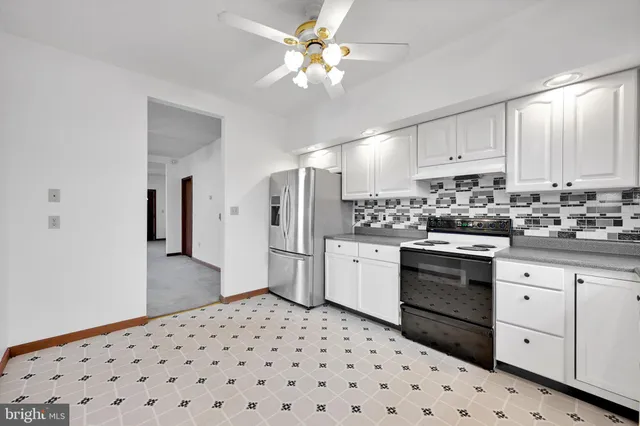 a kitchen with a refrigerator stove and white cabinets