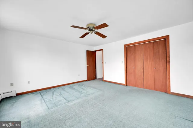 an empty room with closet and windows