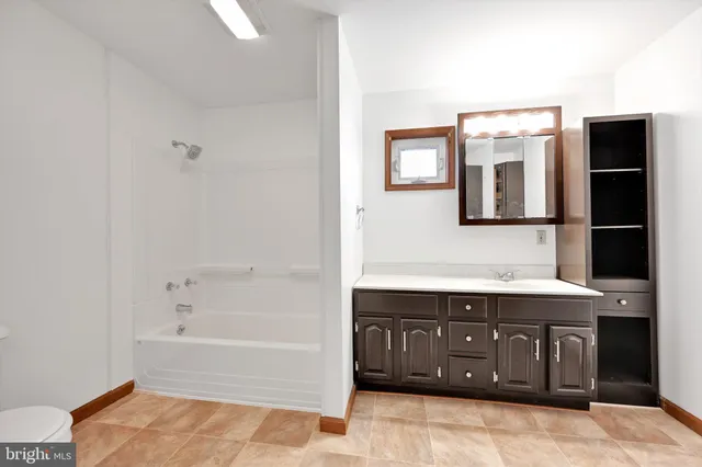 a bathroom with a tub sink and mirror