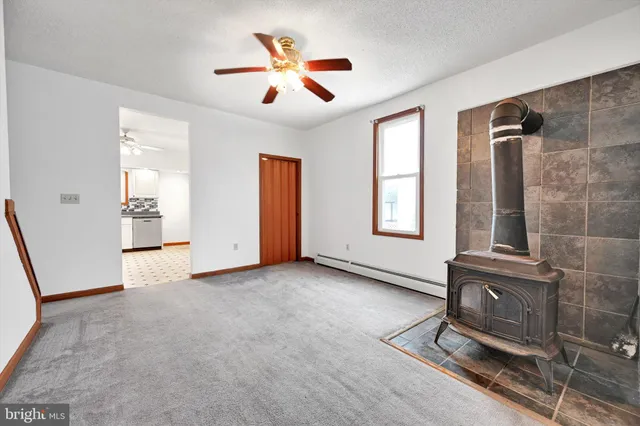 an empty room with windows and ceiling fan