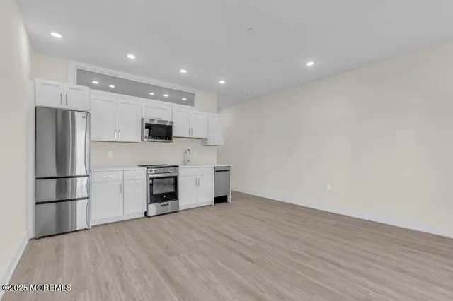 a kitchen with a refrigerator and a stove top oven