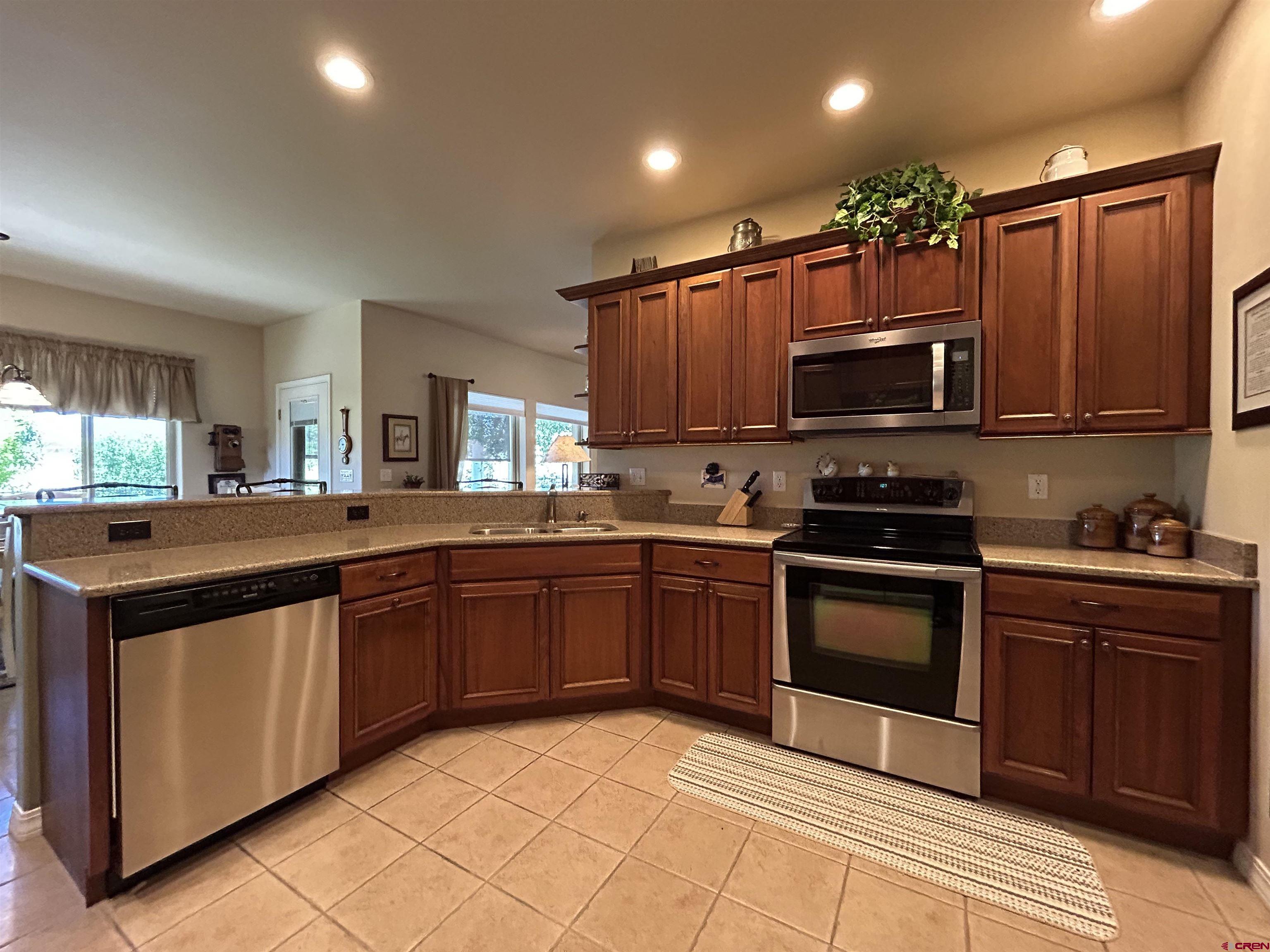 850 Southeast Pinyon Street Cedaredge, CO 81413 - Photo 11 of 45 a kitchen with stainless steel appliances granite countertop a stove top oven a sink dishwasher and cabinets