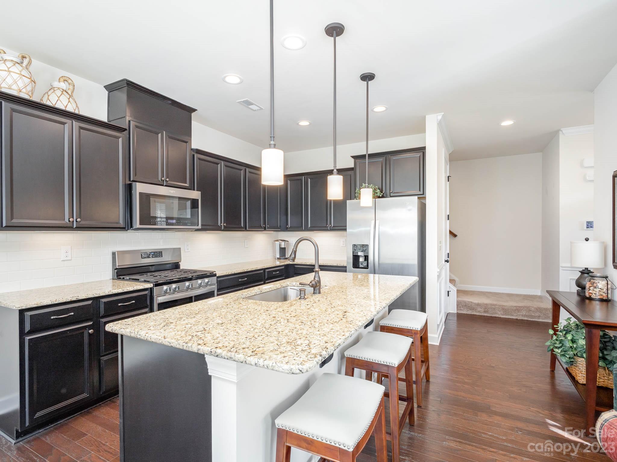 5688 Garrow Glen Road Charlotte, NC 28278 - Photo 3 of 30 a kitchen with stainless steel appliances granite countertop a kitchen island hardwood floor sink stove and kitchen island