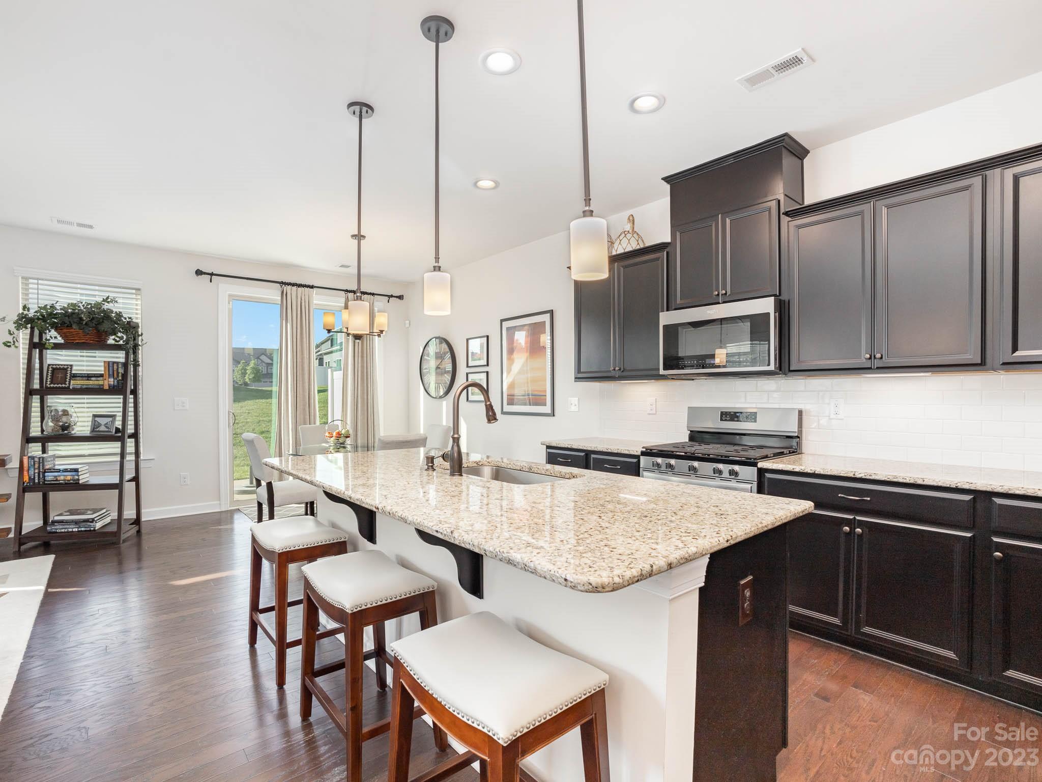 5688 Garrow Glen Road Charlotte, NC 28278 - Photo 4 of 30 a kitchen with stainless steel appliances granite countertop a sink a stove a table and chairs