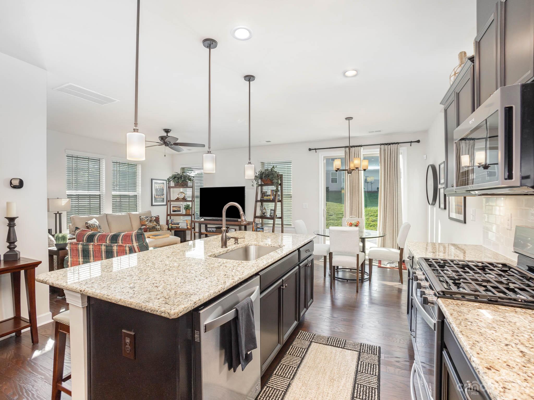 5688 Garrow Glen Road Charlotte, NC 28278 - Photo 5 of 30 a open kitchen with stainless steel appliances granite countertop a stove top oven a sink dishwasher and couches with wooden floor