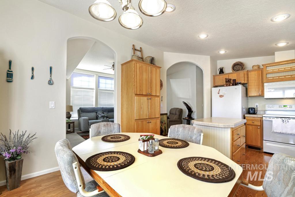 910 Moonglo Road, Unit 14 Buhl, ID 83316 - Photo 11 of 22 Dining area with arched walkways, dark wood-style flooring, and a textured ceiling