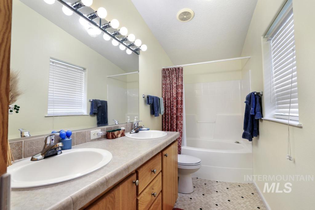 910 Moonglo Road, Unit 14 Buhl, ID 83316 - Photo 14 of 22 Bathroom with double vanity, shower / bathtub combination with curtain, and light tile patterned flooring