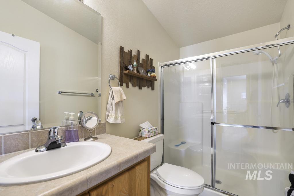 910 Moonglo Road, Unit 14 Buhl, ID 83316 - Photo 17 of 22 Bathroom featuring vanity, a stall shower, and vaulted ceiling