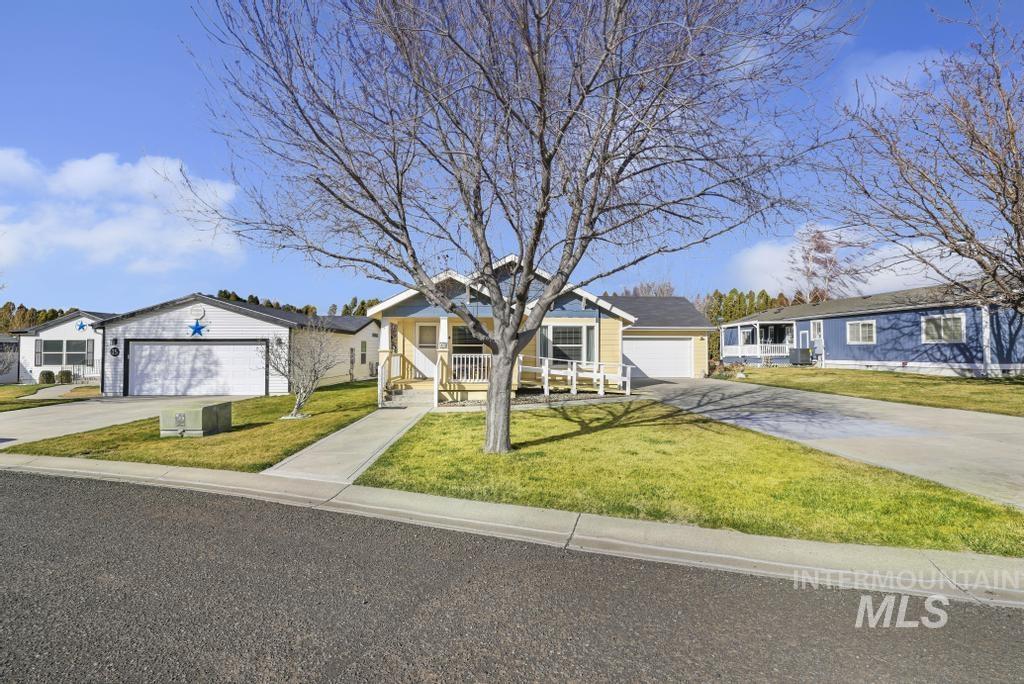 910 Moonglo Road, Unit 14 Buhl, ID 83316 - Photo 2 of 22 Single story home with a porch, a front yard, a garage, and concrete driveway