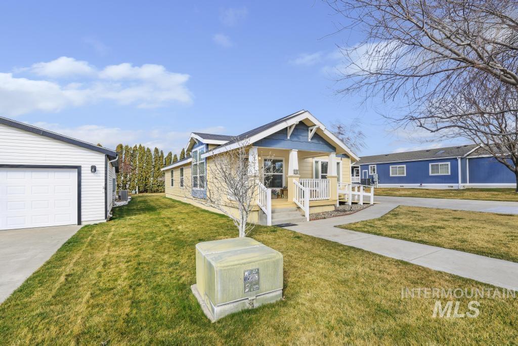 910 Moonglo Road, Unit 14 Buhl, ID 83316 - Photo 3 of 22 View of front facade featuring a front yard, a porch, and a garage