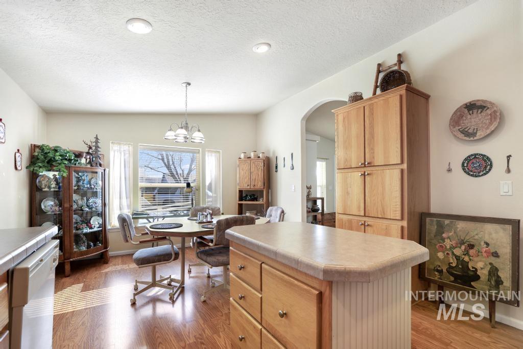 910 Moonglo Road, Unit 14 Buhl, ID 83316 - Photo 8 of 22 Kitchen with arched walkways, white dishwasher, a kitchen island, light wood-style flooring, and light countertops