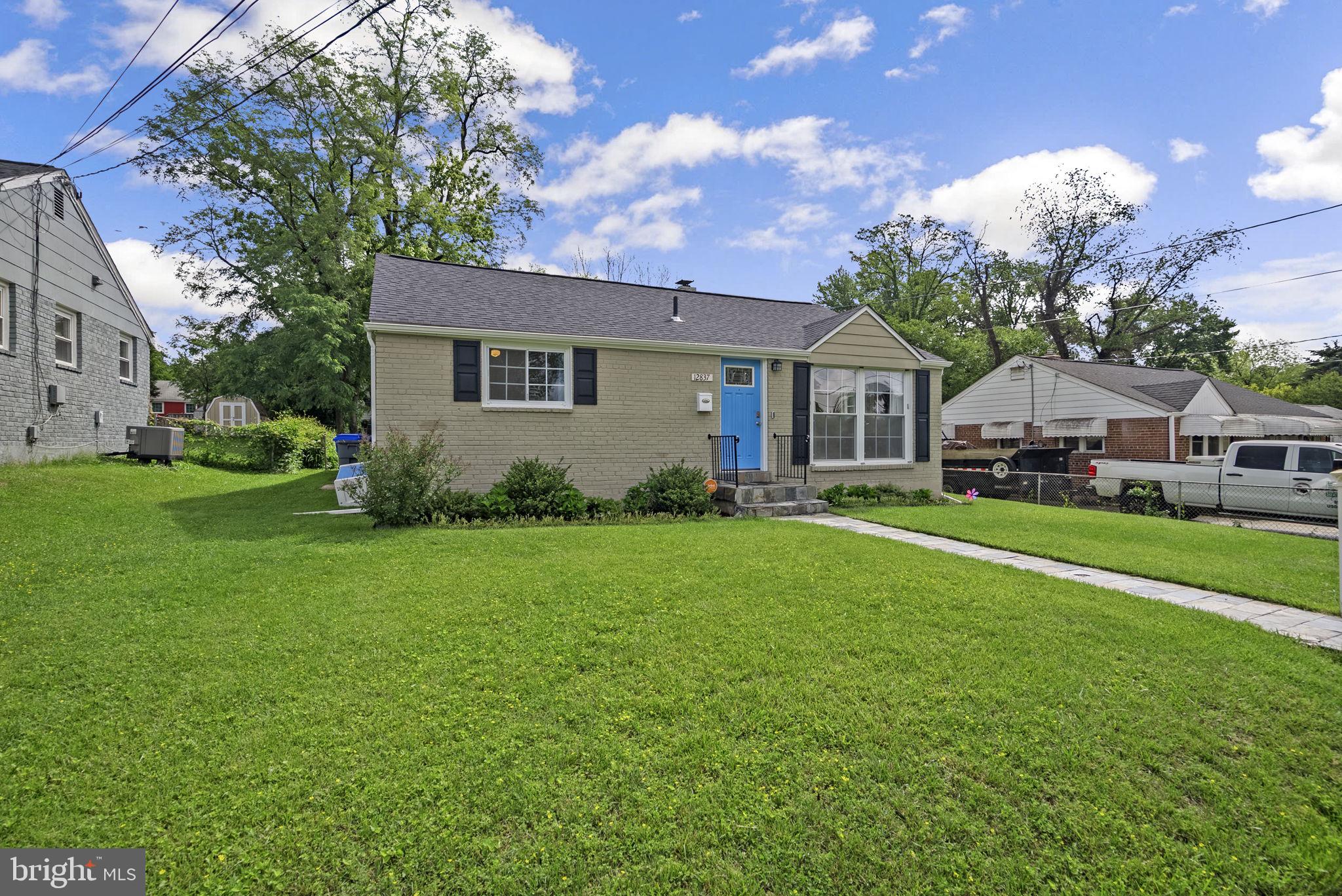 12837 Flack Street Silver Spring, MD 20906 - Photo 1 of 26 a front view of a house with garden