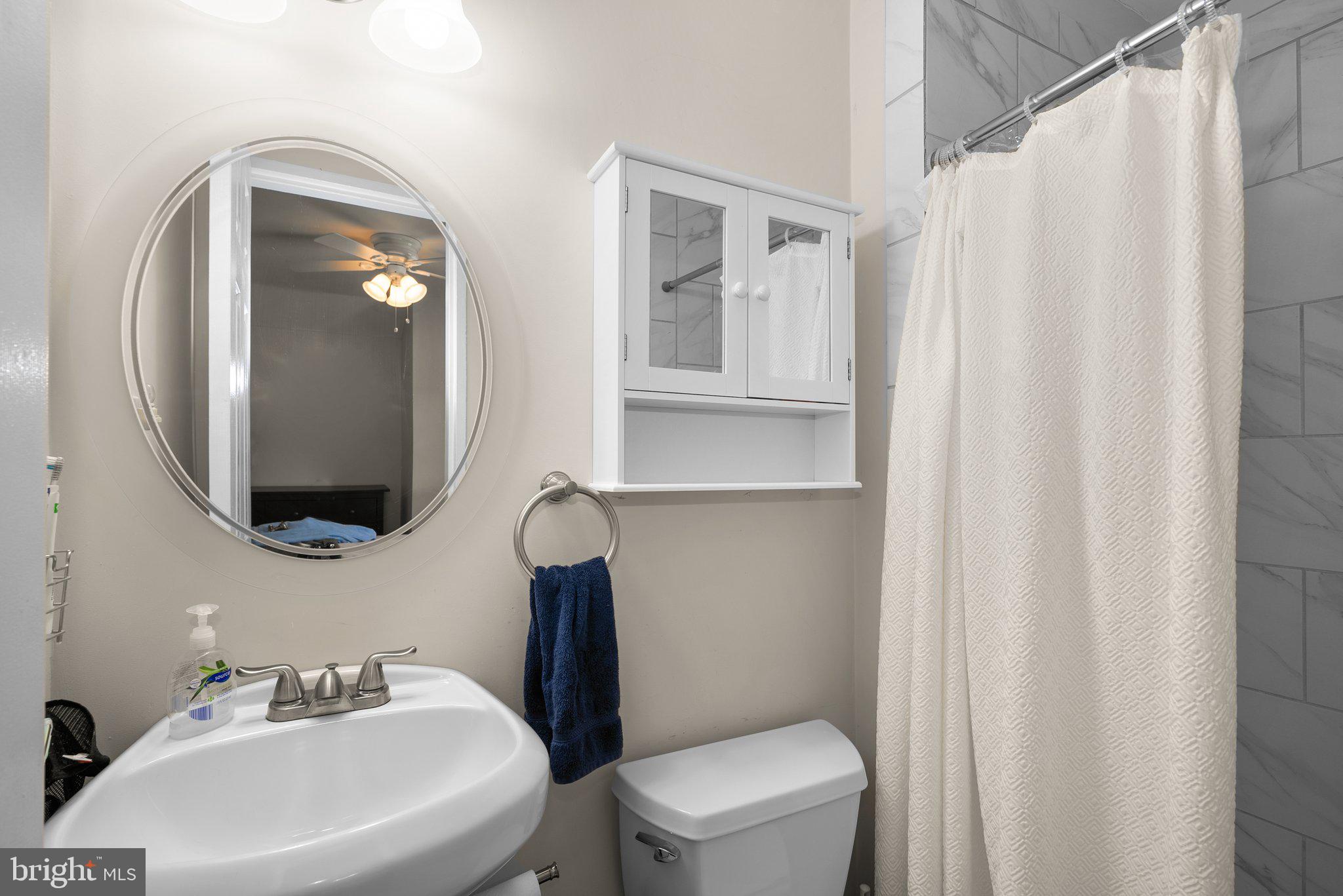 12837 Flack Street Silver Spring, MD 20906 - Photo 20 of 26 a bathroom with a toilet sink and mirror