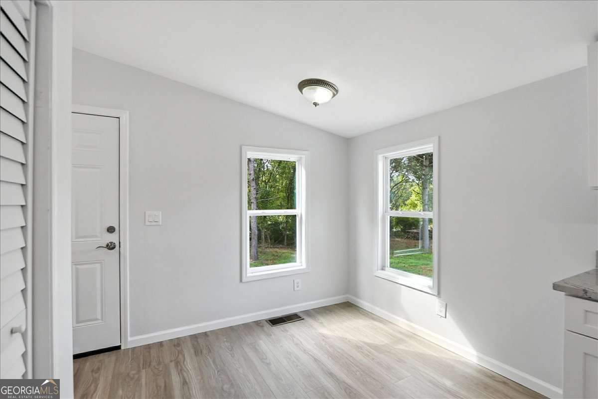 285 Trotters Way Jefferson, GA 30549 - Photo 11 of 28 an empty room with wooden floor and windows