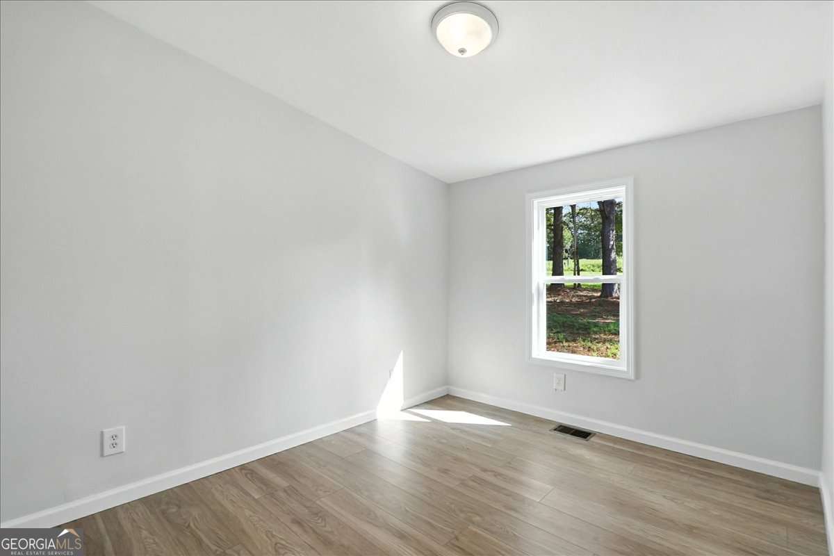 285 Trotters Way Jefferson, GA 30549 - Photo 16 of 28 an empty room with wooden floor and windows