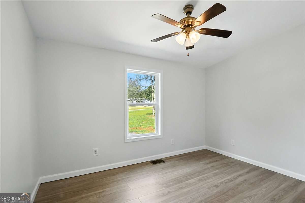 285 Trotters Way Jefferson, GA 30549 - Photo 21 of 28 an empty room with a window and a ceiling fan