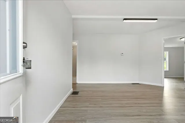 a view of an empty room with wooden floor