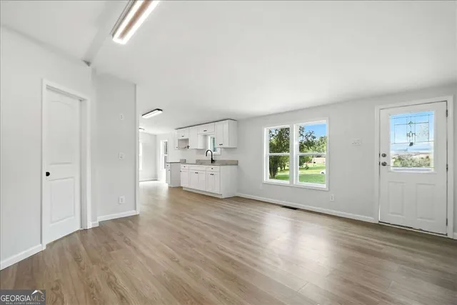 a view of a kitchen with wooden floor and windows