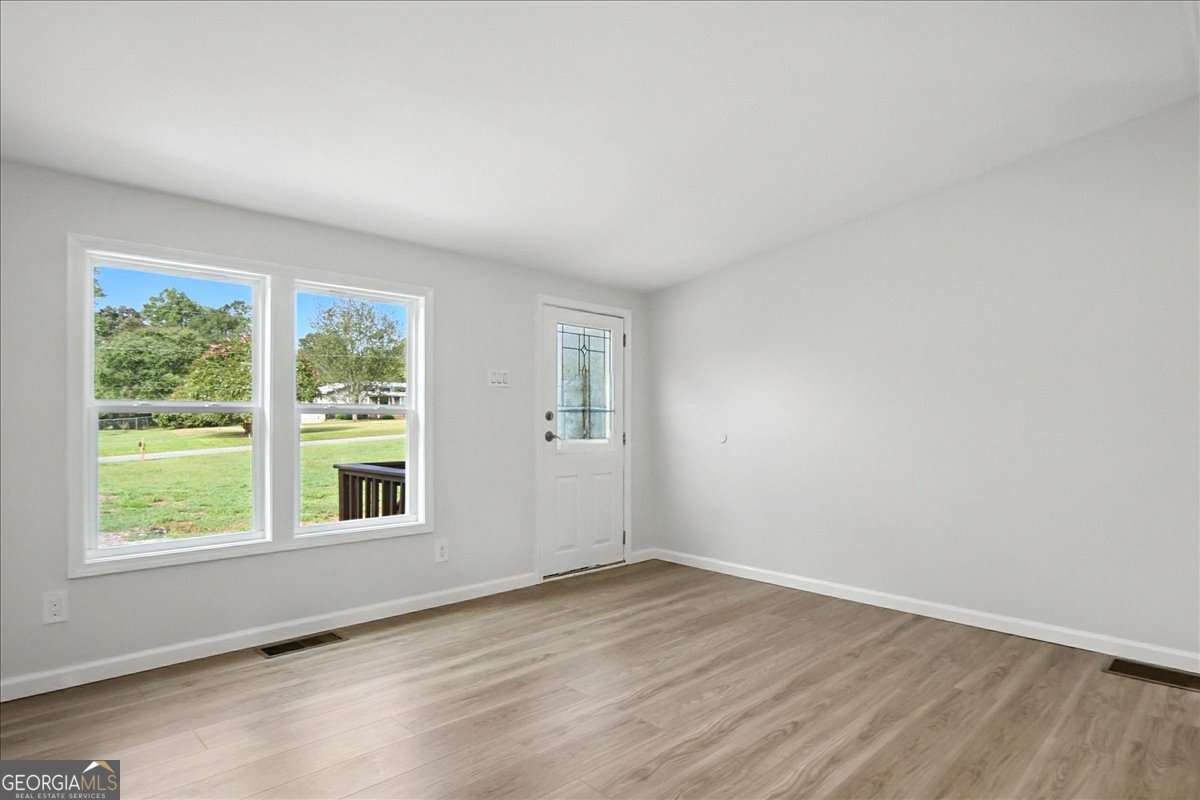 285 Trotters Way Jefferson, GA 30549 - Photo 6 of 28 an empty room with wooden floor and windows
