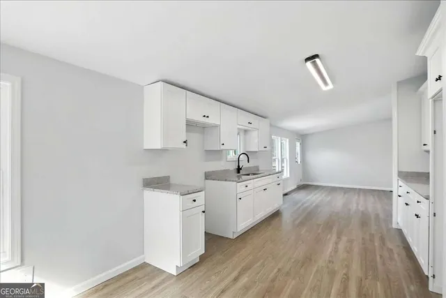 a large kitchen with cabinets wooden floor and stainless steel appliances