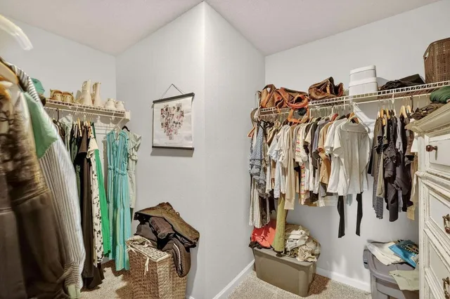 a view of walk in closet with clothes and shoes