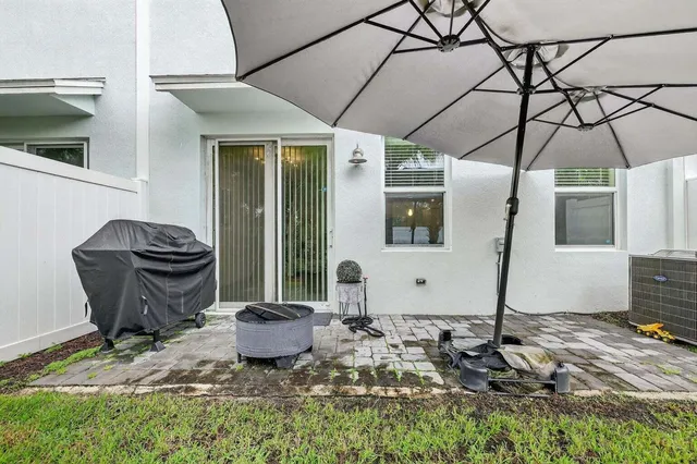 a view of a backyard with table and chairs and wooden fence