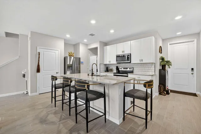 a kitchen with kitchen island granite countertop wooden cabinets and stainless steel appliances
