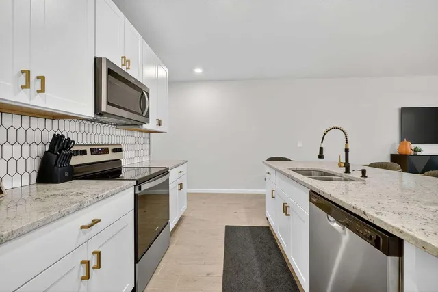 a kitchen with stainless steel appliances granite countertop a sink stove and refrigerator