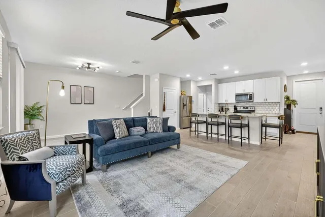 a living room with furniture and kitchen view