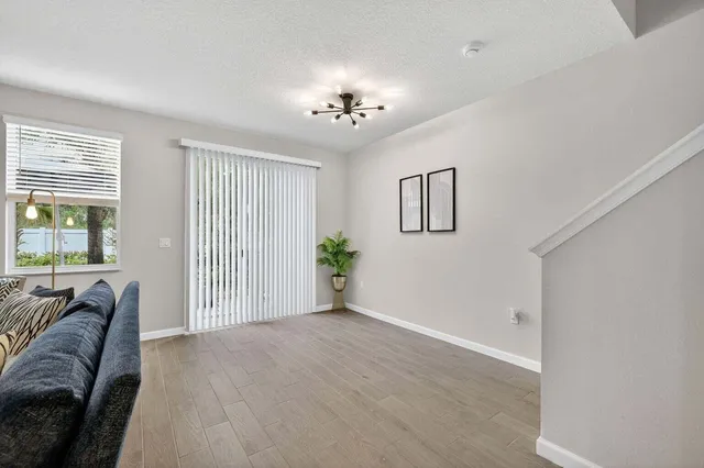a view of a livingroom with a chandelier fan and windows