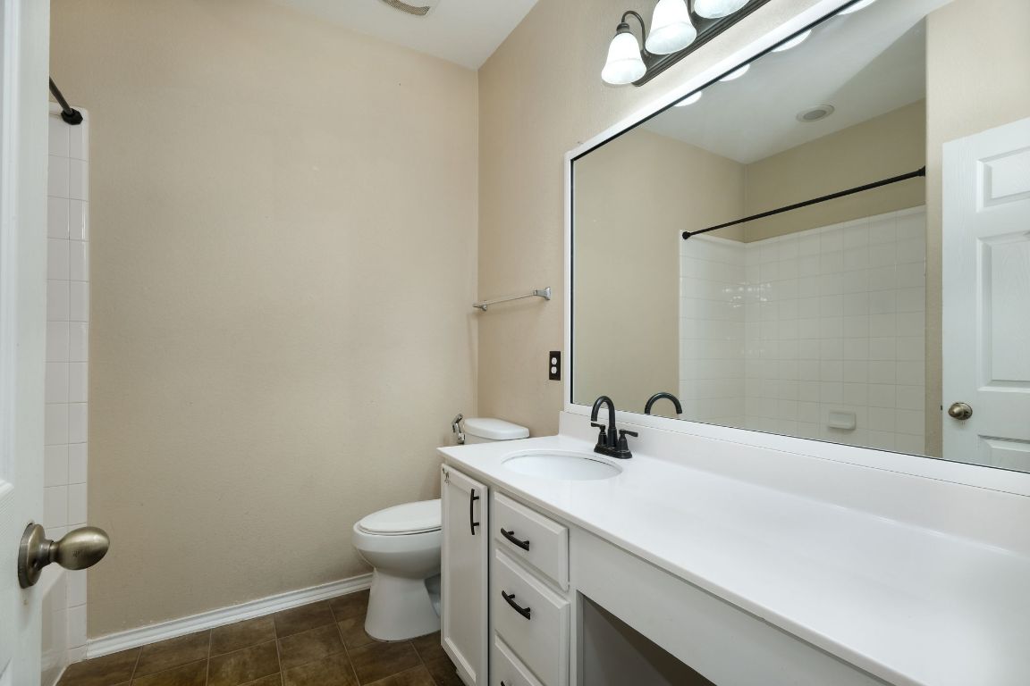 1244 Yellow Iris Road Leander, TX 78641 - Photo 17 of 25 a bathroom with a double vanity sink toilet and a mirror