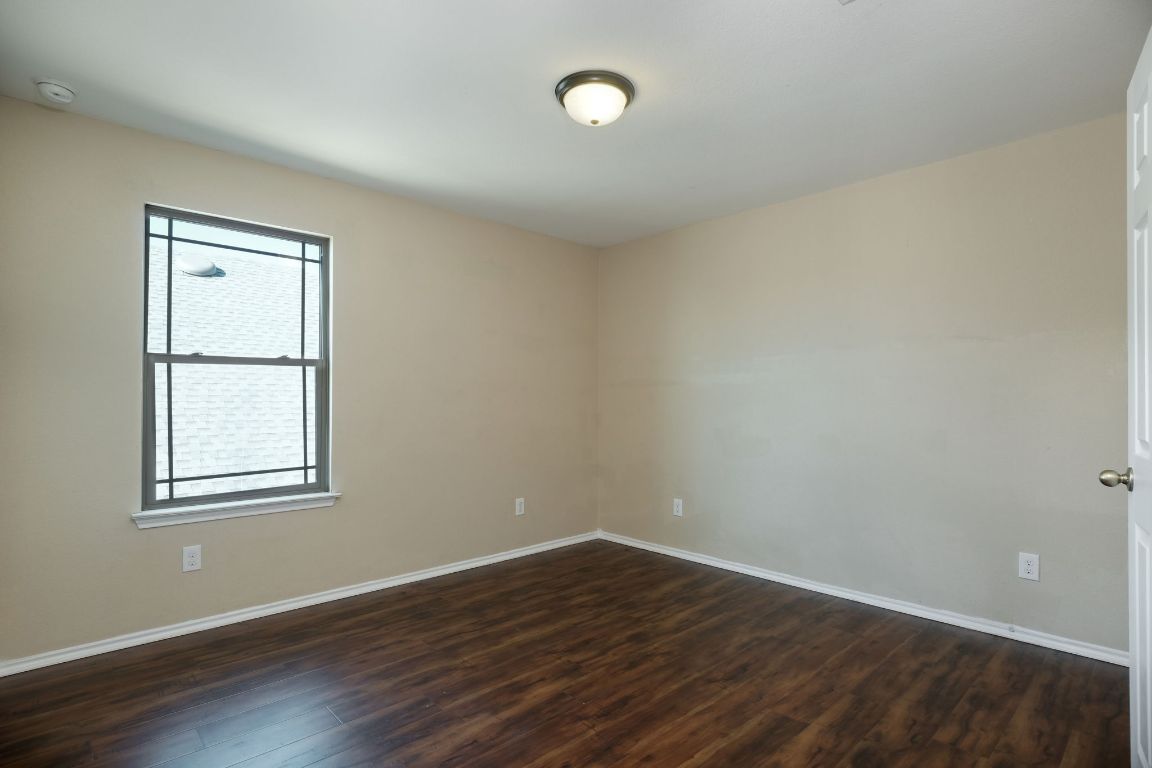 1244 Yellow Iris Road Leander, TX 78641 - Photo 20 of 25 a view of an empty room with wooden floor and a window