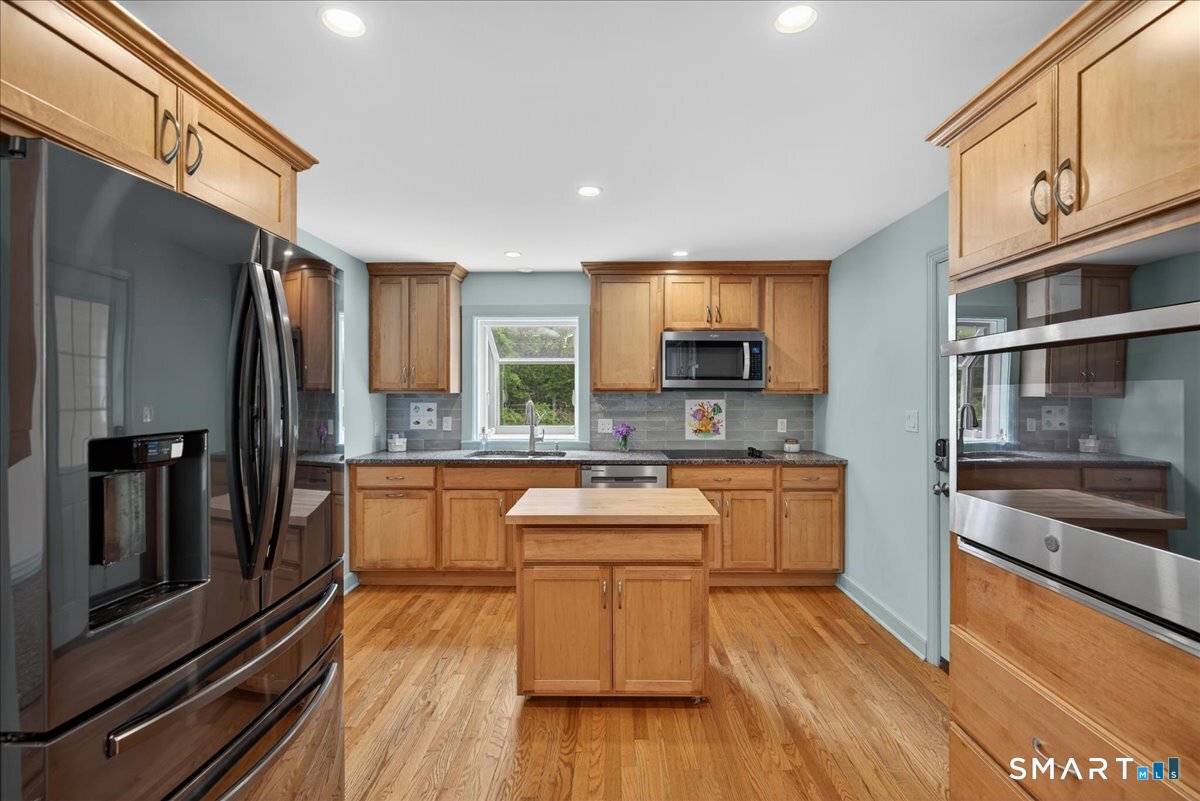 1006 King Road Cheshire, CT 06410 - Photo 4 of 40 The spacious kitchen includes high end touches like beautiful cabinetry, hardwood floors, in-wall oven, and granite counters.