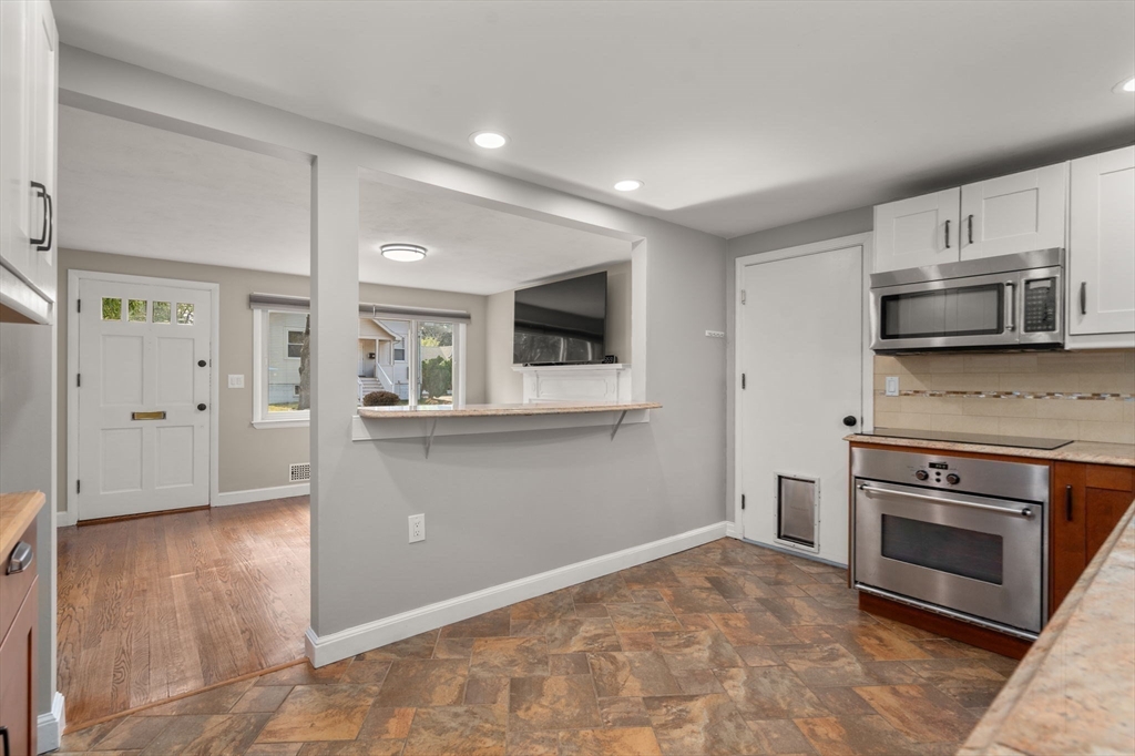 19 Wellesley Road Natick, MA 01760 - Photo 11 of 23 a kitchen with granite countertop a stove and a microwave
