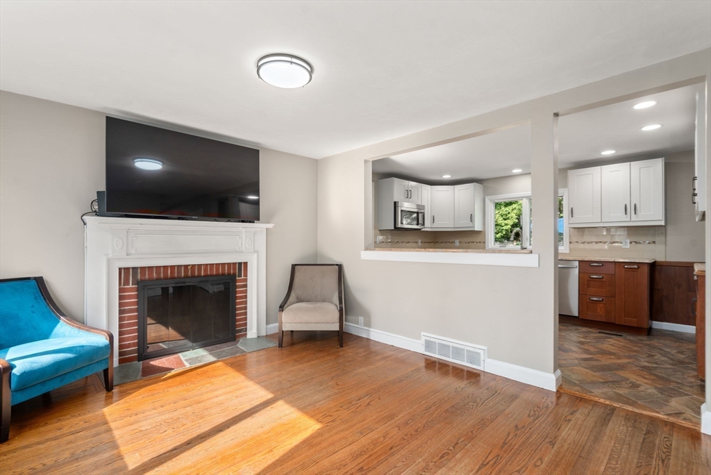 19 Wellesley Road Natick, MA 01760 - Photo 12 of 23 a living room with a fireplace and a flat screen tv