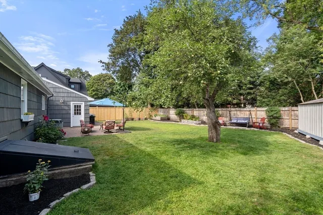 a view of a house with backyard and sitting area