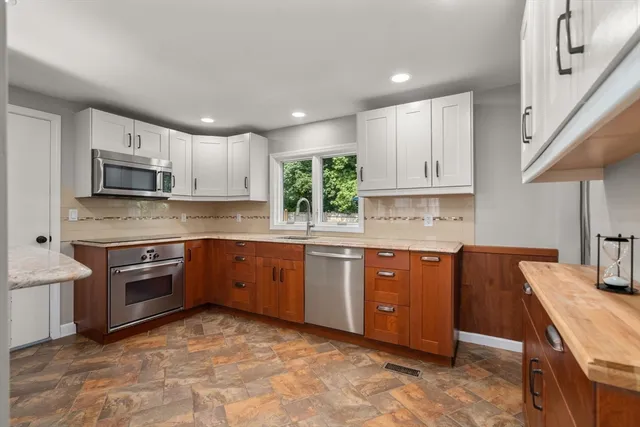 a kitchen with stainless steel appliances granite countertop a stove sink and cabinets