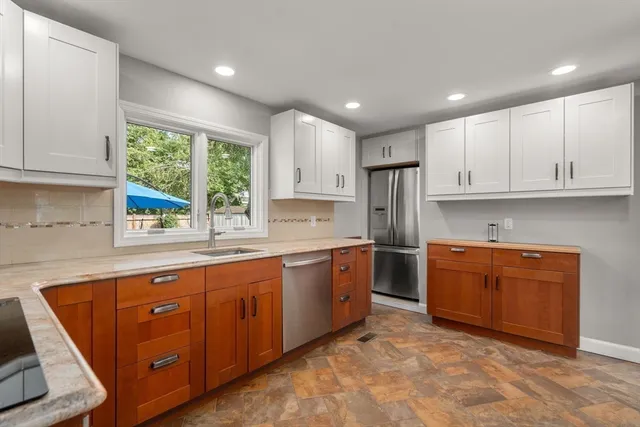 a kitchen with stainless steel appliances granite countertop wooden cabinets a sink and a stove