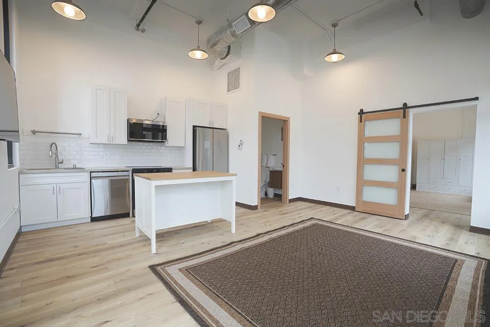 a large white kitchen with a refrigerator a stove top oven a sink and dishwasher