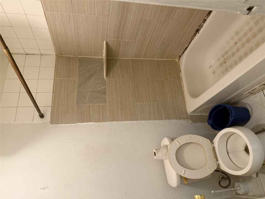 7703 Northcrest Boulevard Austin, TX 78752 - Photo 13 of 22 a bathroom with a toilet a sink and bathtub