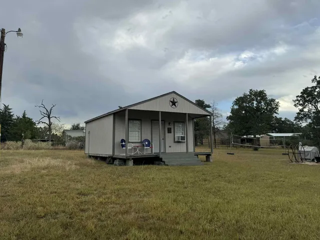 a view of a house with backyard and sitting area