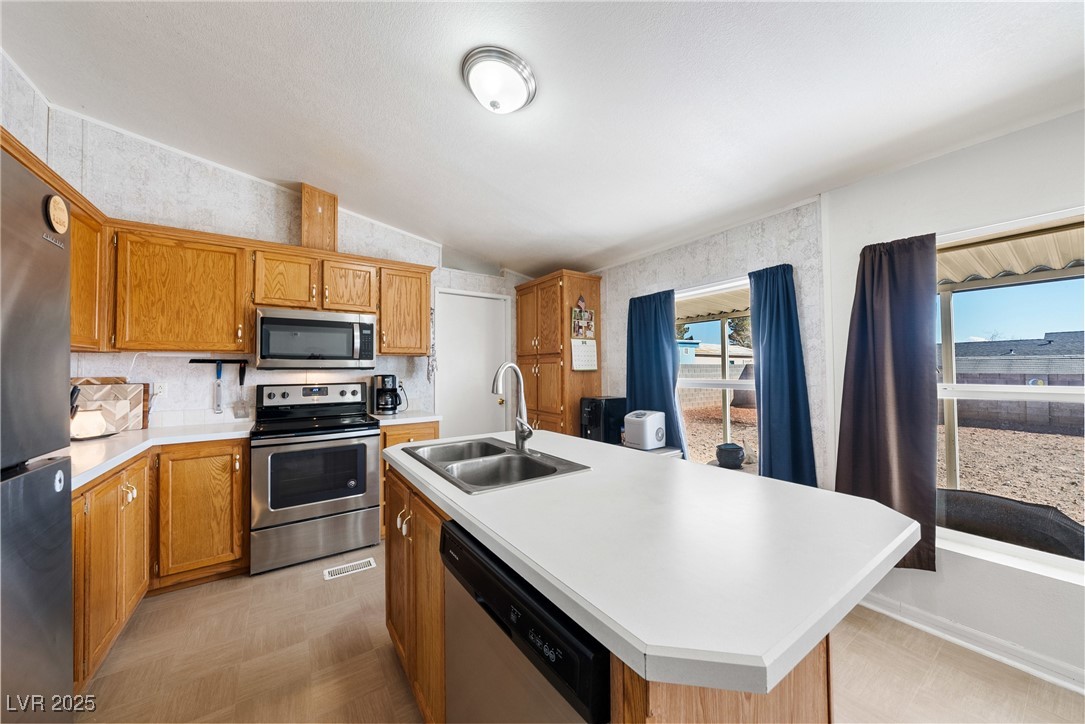 633 East Simkins Road Pahrump, NV 89060 - Photo 9 of 25 Kitchen with lofted ceiling, stainless steel appliances, a sink, and light countertops