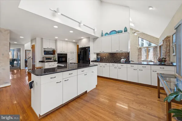a large kitchen with stainless steel appliances lots of counter space sink refrigerator and cabinets