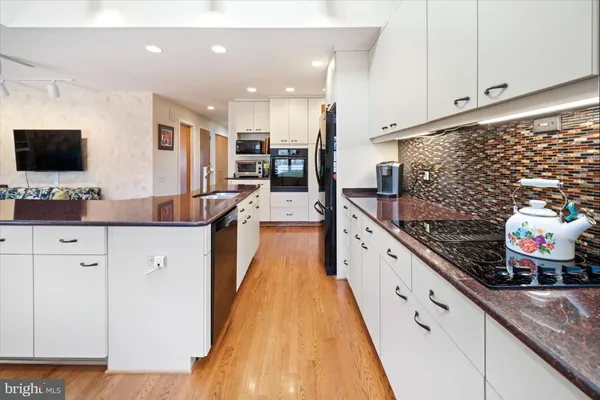 a large kitchen with stainless steel appliances kitchen island granite countertop a sink and cabinets