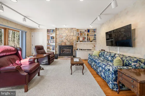 a living room with furniture a flat screen tv and a fireplace